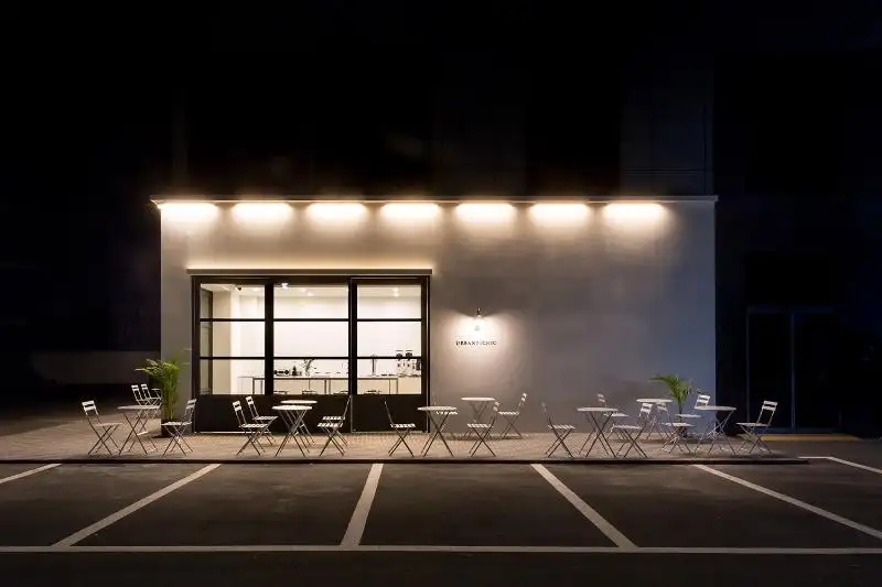 간결한 조명과 외부 테이블로 꾸며진 세련된 카페 외관